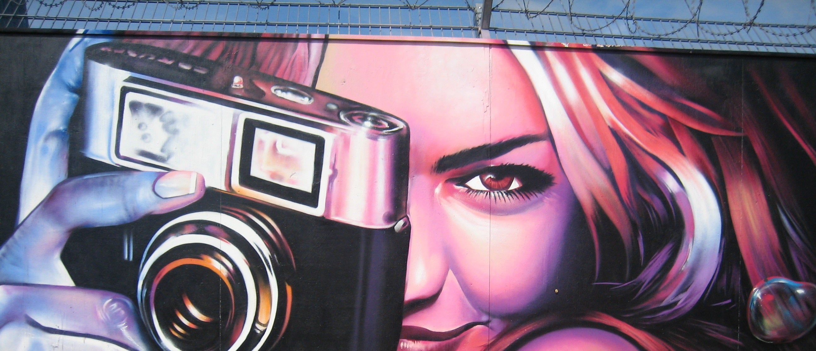Mural of a woman holding a camera with vibrant colors
